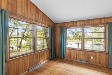 The wood-paneled living room offers this panoramic view of the pond.