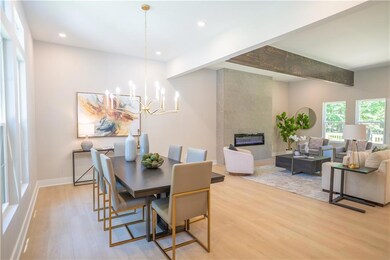 Dining space featuring light wood finished floors, a chandelier, a tile fireplace, recessed lighting, and baseboards