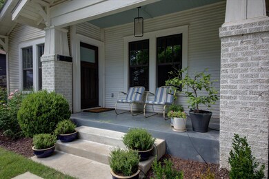 Property entrance with a porch and brick siding