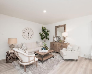 Living area with wood finished floors and recessed lighting