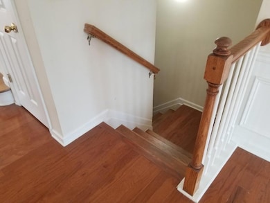 Stairway featuring baseboards and wood finished floors
