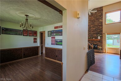 Hall featuring a chandelier, a textured ceiling, and tile floors