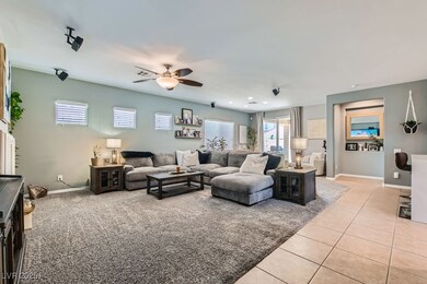 Living area with a ceiling fan, light tile pattern