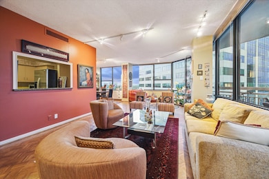The living area showcases rich wood flooring, mode