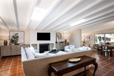 Tiled living room featuring beam ceiling