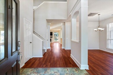 Entryway with baseboards, a notable chandelier, w