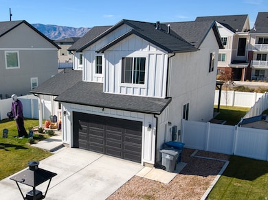 Modern farmhouse featuring board and batten siding, driveway, a shingled roof, a garage, and a residential view