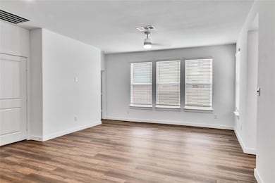 Empty room with ceiling fan, wood finished floors,