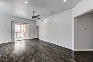 Unfurnished room featuring ceiling fan, dark wood-
