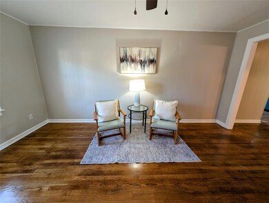 Sitting room with crown molding, wood finished floors, and baseboards
