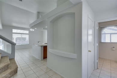 Corridor with light tile patterned floors, stairs,
