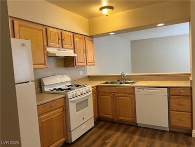Kitchen with white appliances, a sink, under cabin