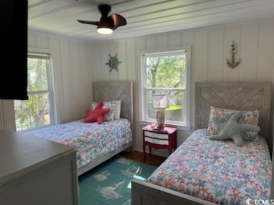 Bedroom featuring multiple windows, ceiling fan, and dark wood-style floors
