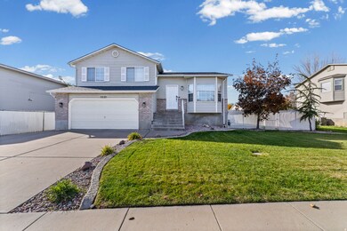 Split level home featuring brick siding, driveway, and an attached garage