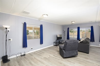 Living area with light wood-style floors, healthy amount of natural light, and wooden walls