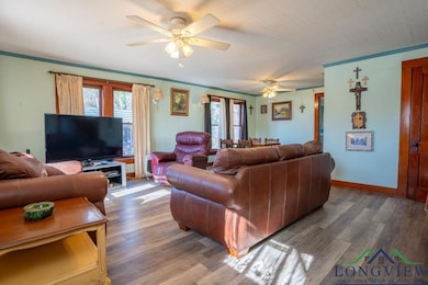 Living room featuring ceiling fan, crown molding, 