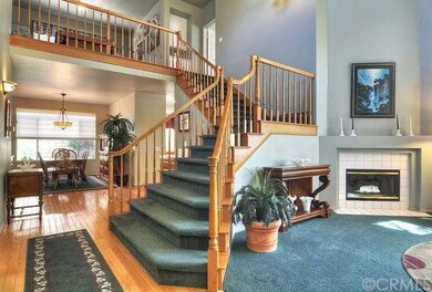 A DRAMATIC STAIRCASE SPIRALS INTO THE HALLWAY AND 