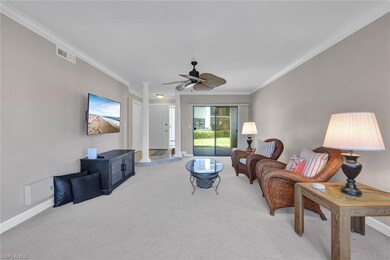 Living room featuring carpet, ornate columns, ceiling fan, and ornamental molding