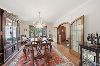 Dining room featuring crown molding, Stain glass Doors and a Swarovski chandelier.