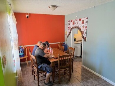Dining room featuring a textured ceiling and dark tile patterned flooring