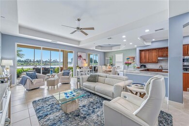 Living area with a tray ceiling, light tile patterned floors, ceiling fan, and recessed lighting