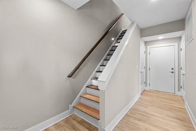 Stairway with baseboards and wood finished floors