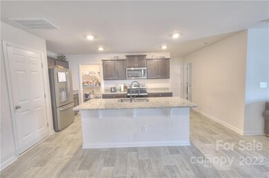 Almost new kitchen with large island, granite countertops and stainless appliances