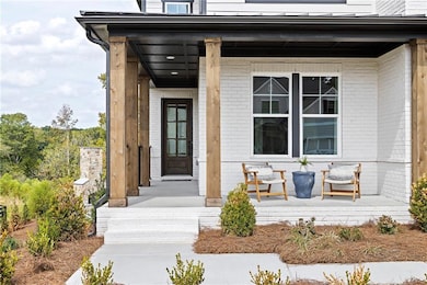 View of exterior entry with brick siding and a porch. Photo is representative of the Acworth Model Home. Designer features will vary.