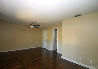 Unfurnished room with visible vents, dark wood-style flooring, baseboards, and ceiling fan