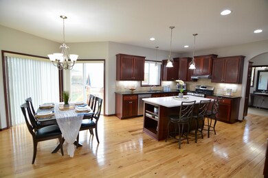 Huge Gourmet kitchen with big center island with a new quartz top.  Custom Cherry cabinets with granite counter tops. Ceramic tile backsplash, stainless steel appliances and gleaming hardwood floors. Bright and open informal dining room.