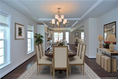 Tray ceiling and hardwood floors continue into dining room which opens to kitchen. Note: room was virtually staged.