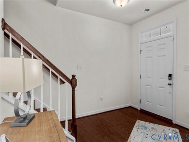 Entryway with dark wood finished floors and baseboards