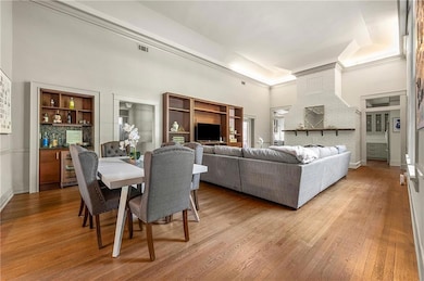Dining area with hardwood / wood-style floors and a high ceiling