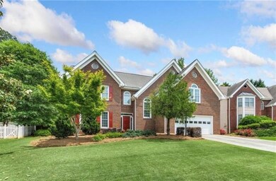 View of front of property featuring driveway, brick siding, and a garage