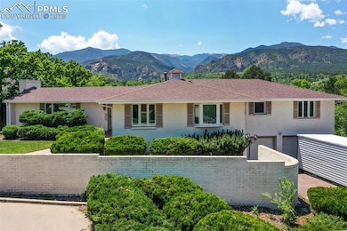 Ranch-style house featuring a mountain view, a garage, and a chimney