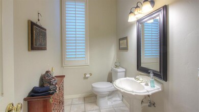 One of two half baths down. Tile floor, updated mirror and lighting. Shutter on window. Pedestal sink. Bath is located off the Office and Family room.