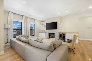 Living Room Featuring a Fireplace, Built In Shelving, and Wine Refrigerator