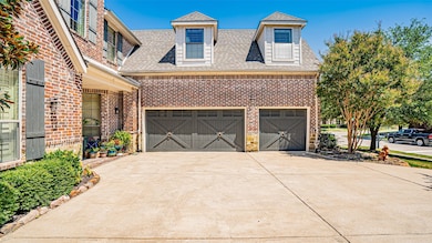 View of front of house featuring a shingled roof, brick siding, a garage, and concrete driveway