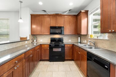 Kitchen featuring black appliances, brown cabinet