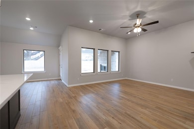Unfurnished living room featuring ceiling fan and 
