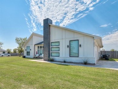 View of front of property with brick siding, board and batten siding, and a chimney