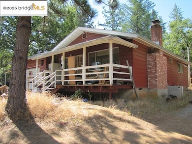 View of front facade with crawl space, covered porch, and a chimney