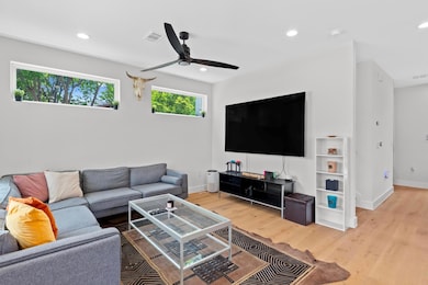 Living area featuring a ceiling fan, visible vent