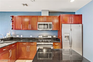 Kitchen with visible vents, a sink, dark stone cou