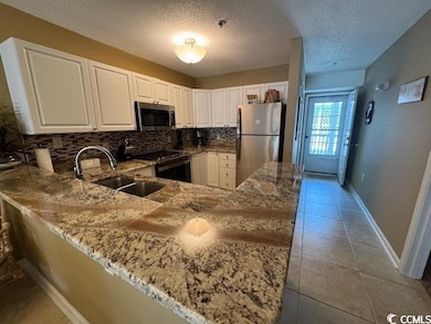 Kitchen with stainless steel appliances, a sink, l