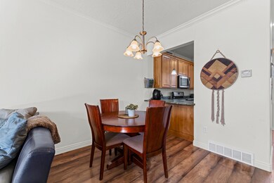 Dining space with crown molding, dark wood finished floors, and a chandelier