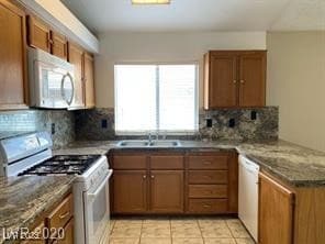 Kitchen with white appliances, brown cabinets, and