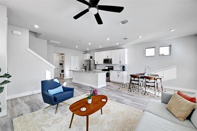 Living room with a ceiling fan, visible vents, ba