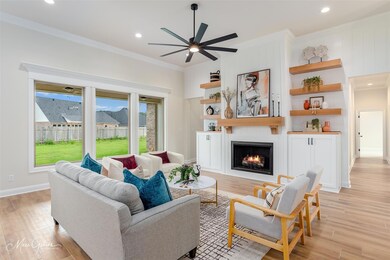 Living room with ceiling fan, a large fireplace, a