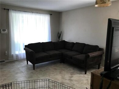 View of living room that has a big picture window.